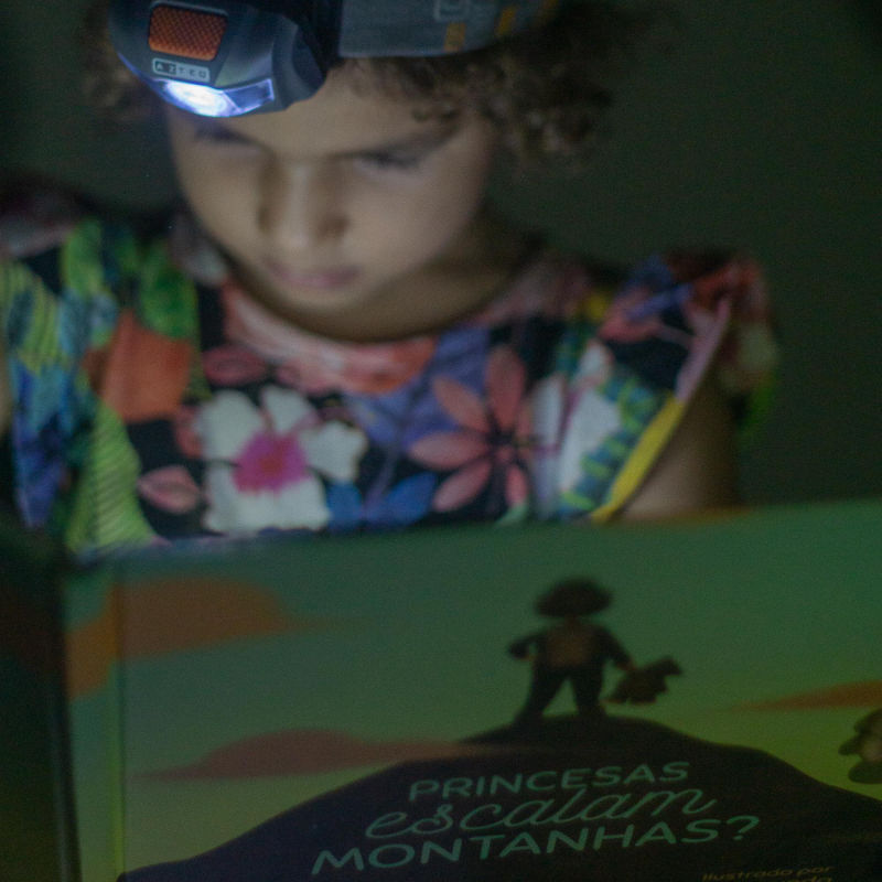 Maya se distraindo com um livro depois de um dia de trilha